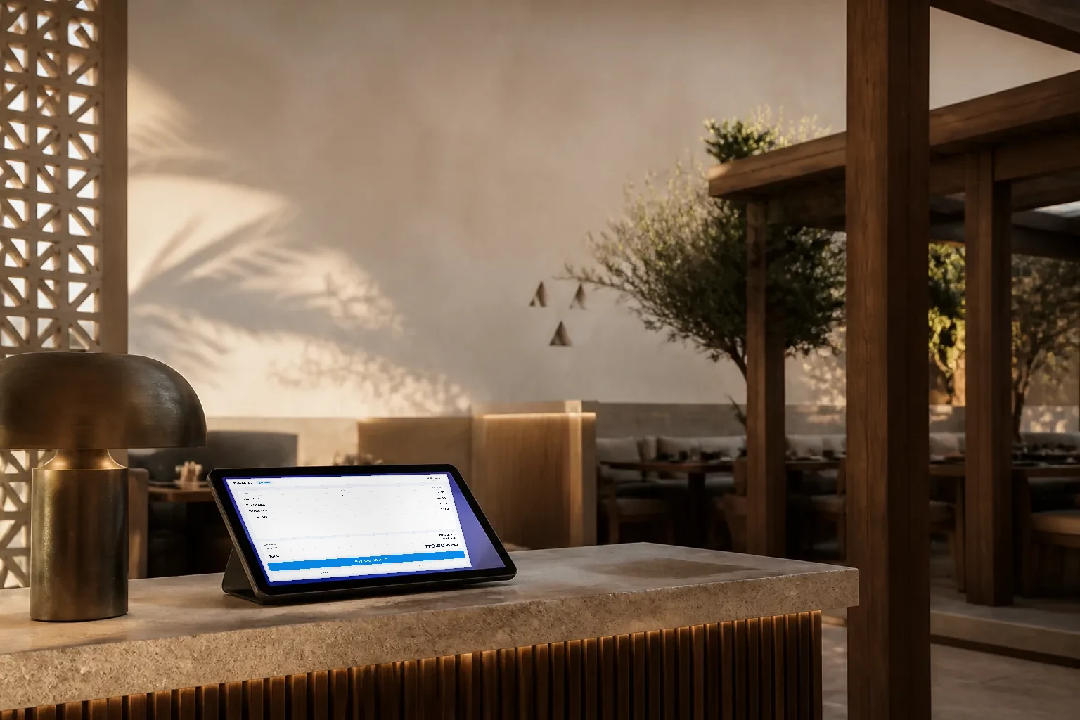 A contemporary Riyadh restaurant interior with carved Najdi plaster details and a tablet glowing on the host counter.